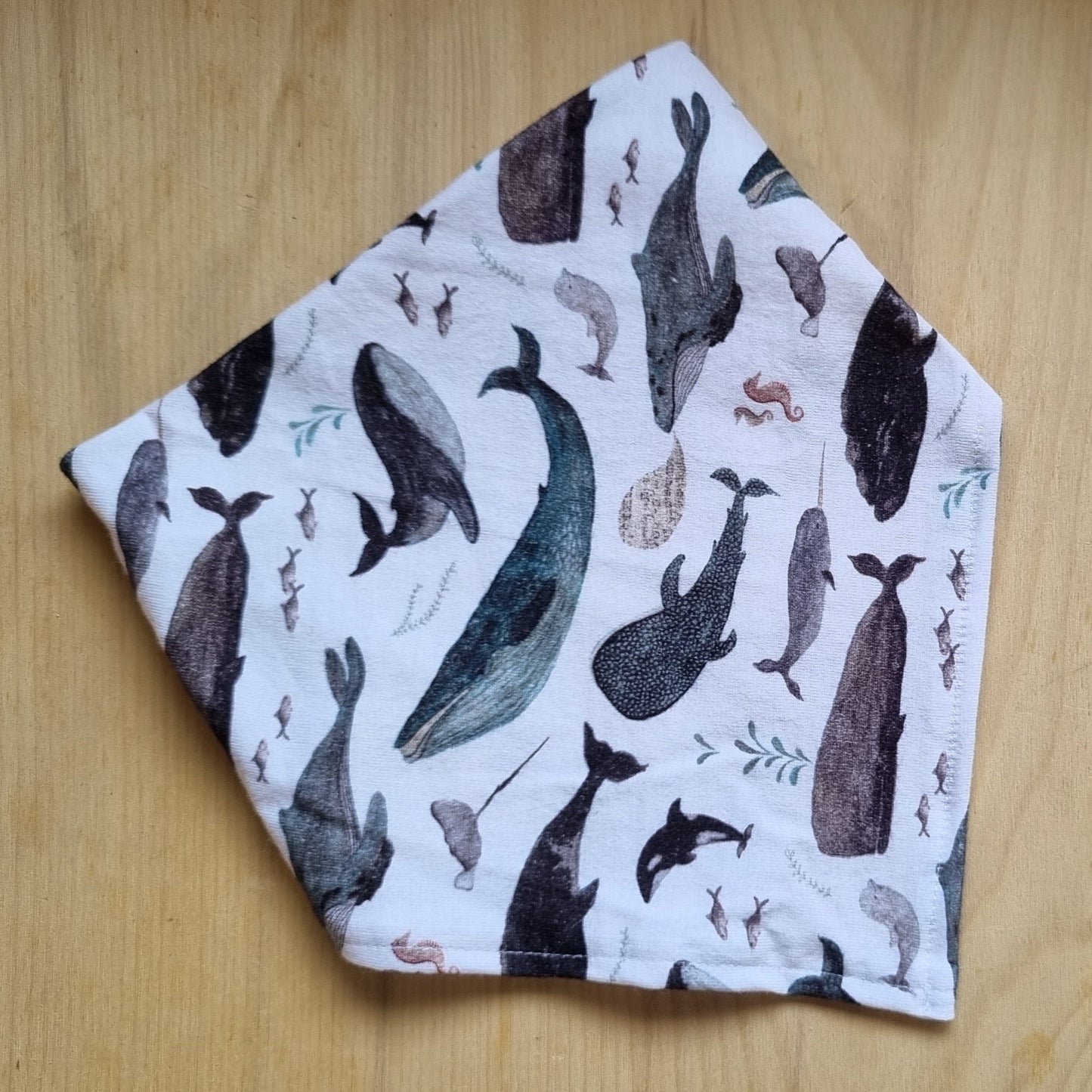 Folded fabric with whale pattern on a wooden surface